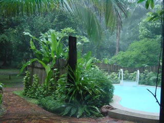 De tuin en zwembad in de regen